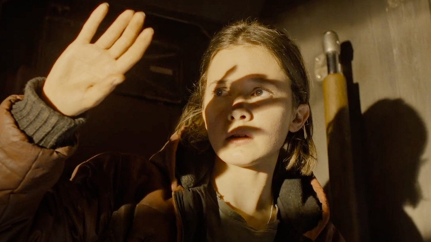 Screenshot of actor Cailee Spaeny as main character Rain in Alien: Romulus. She is holding her hand up to shield her eyes from bright sunlight.