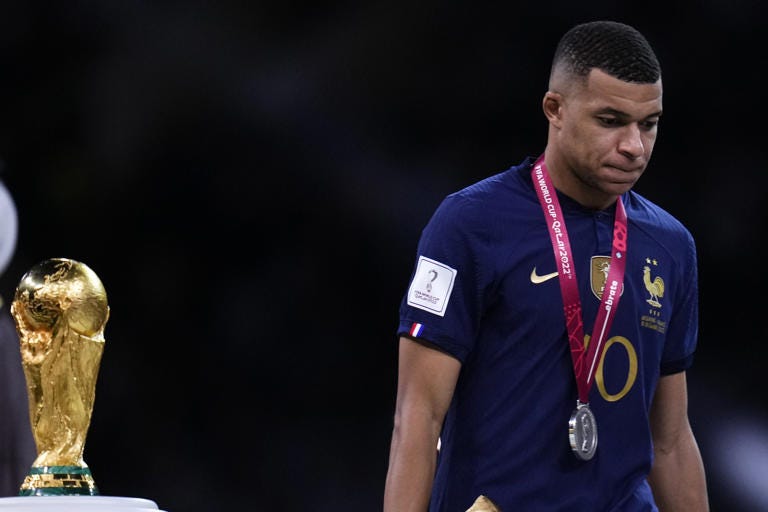 France's Kylian Mbappe walks past the trophy at the end of the World Cup final soccer match between Argentina and France at the Lusail Stadium in Lusail, Qatar, Sunday, Dec.18, 2022. (AP Photo/Manu Fernandez)