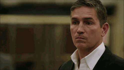 a man in a suit and white shirt is looking at the camera a man in a suit and white shirt is looking at the camera