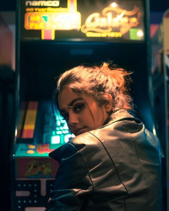This may contain: a woman is sitting in front of a slot machine and looking at her cell phone