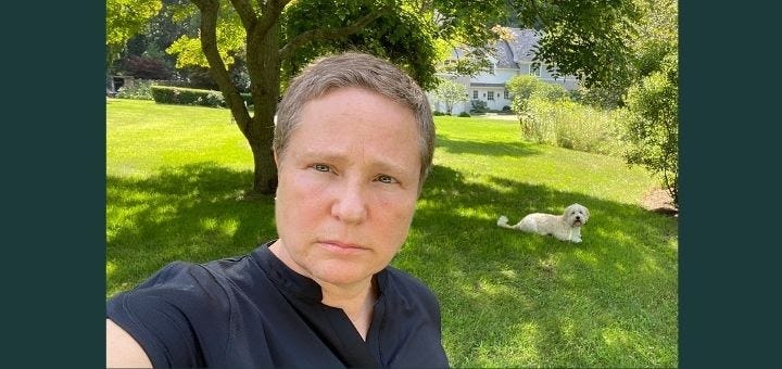 Outdoor selfie of MK with her dog in the background