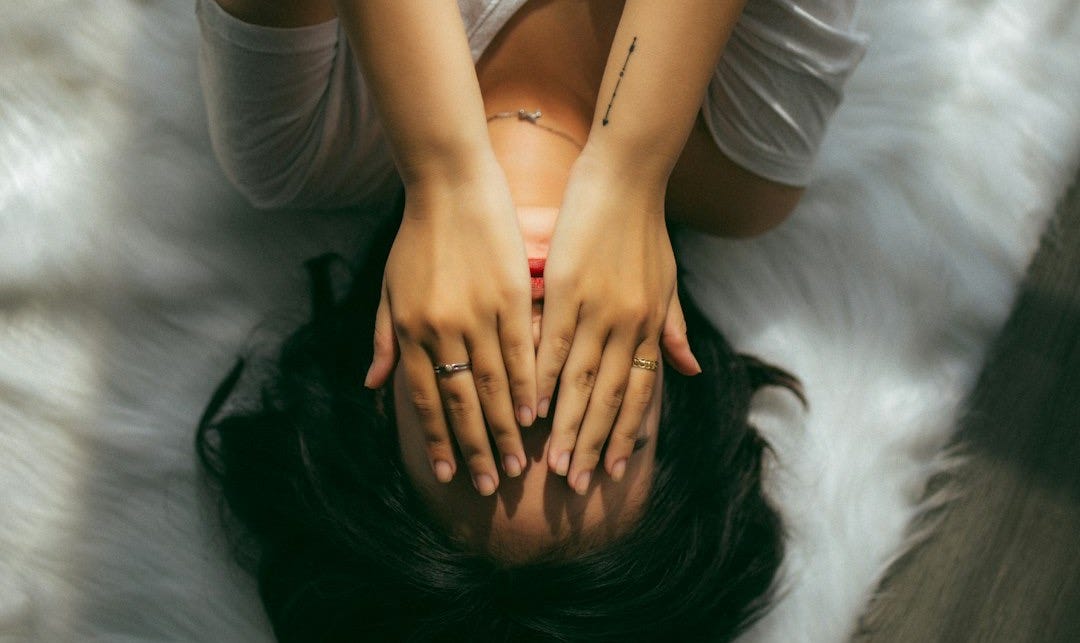 a woman holds her hands over her face a woman holds her hands over her face