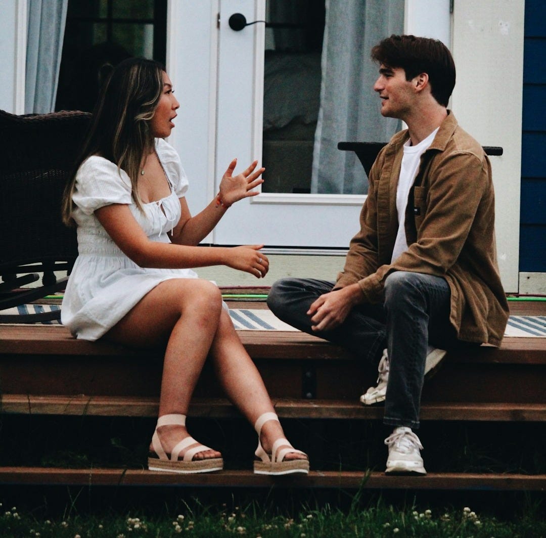 a man and woman sitting on a porch