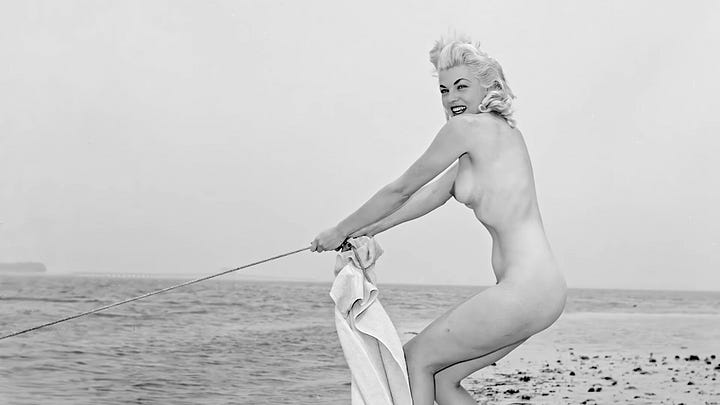 A four-image grid of vintage black-and-white photographs connected to Bunny Yeager: the top-left shows Yeager holding a camera while photographing a nude model lounging on the deck of a boat; the top-right shows a nude woman posing in a dramatic stance on an empty beach; the bottom-left shows a nude woman playfully pulling on a rope at the shoreline; and the bottom-right shows a woman in a bubble bath turning toward the camera with a smile.