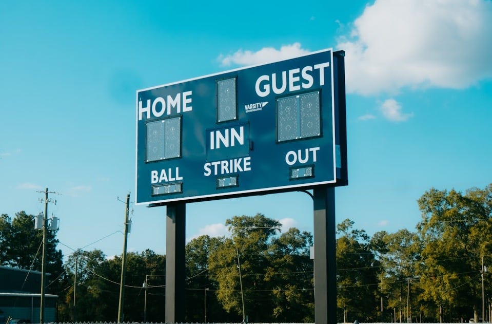 A baseball field with a large sign on it