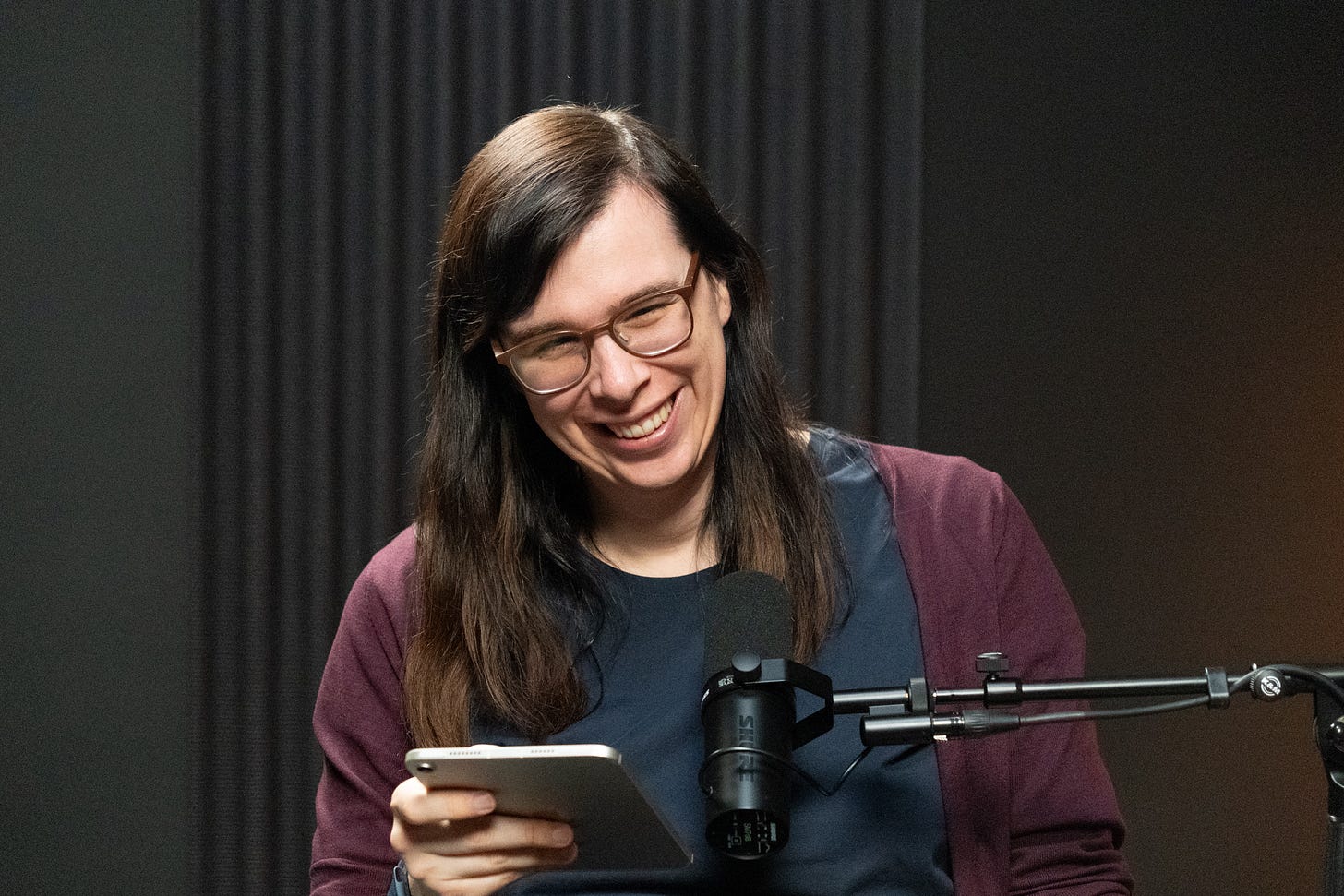 Stefanie Hetjens smiling while preparing for a podcast interview with a microphone in front of her. Stefanie Hetjens smiling while preparing for a podcast interview with a microphone in front of her.