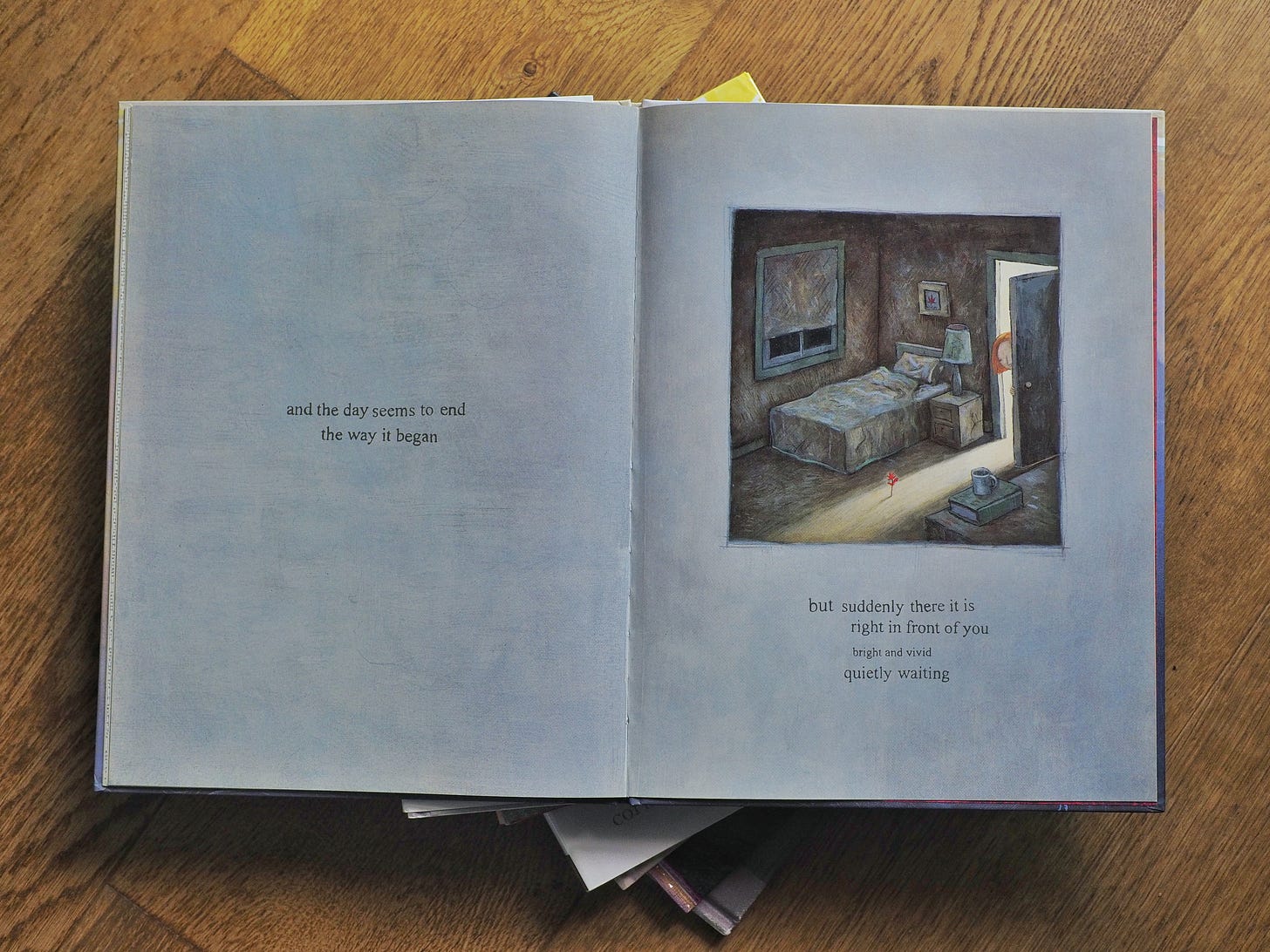 A photo of a spread from Shaun Tan’s ‘The Red Tree’. It reads: “and the day seems to end the way it began but suddenly there it is right in front of you bright and vivid quietly waiting”