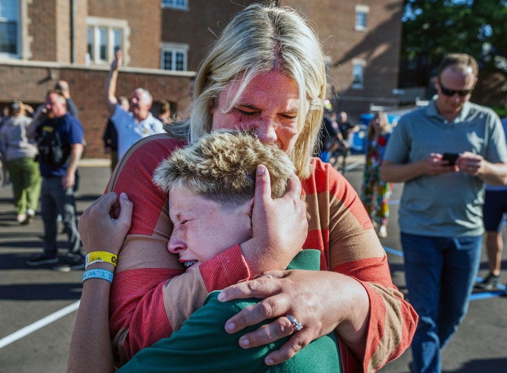 A parent hugs her son after a shooting at the Church of Annunciation in Minneapolis on Wednesday.