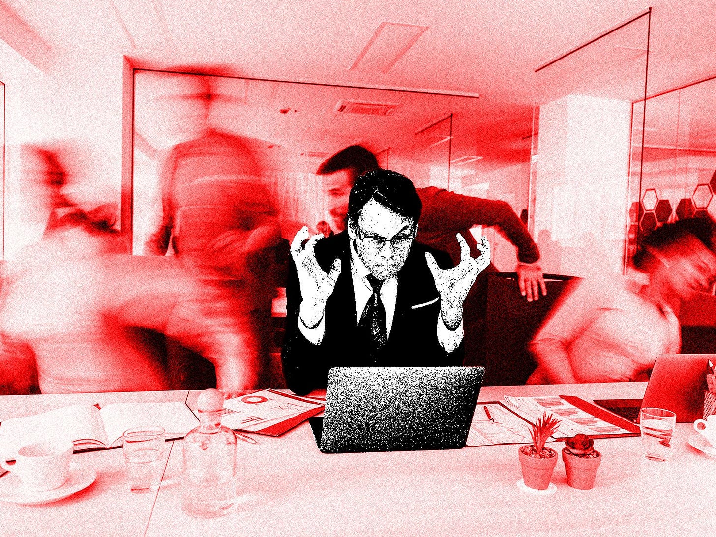 A photo illustration of a frustrated businessman reading a problematic email on a laptop in the office. His colleagues...