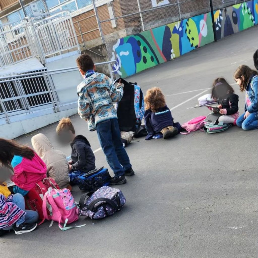 Children on a playground uses their iPads instead of interacting.