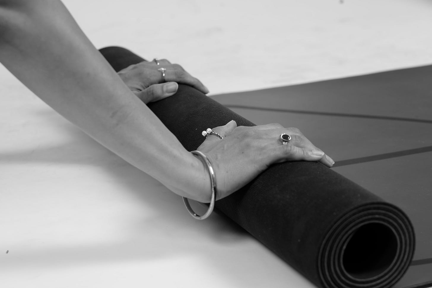 Madhura Bhagwat rolling back a yoga mat after a session, symbolising the completion of practice and the transition into reflection and stillness.