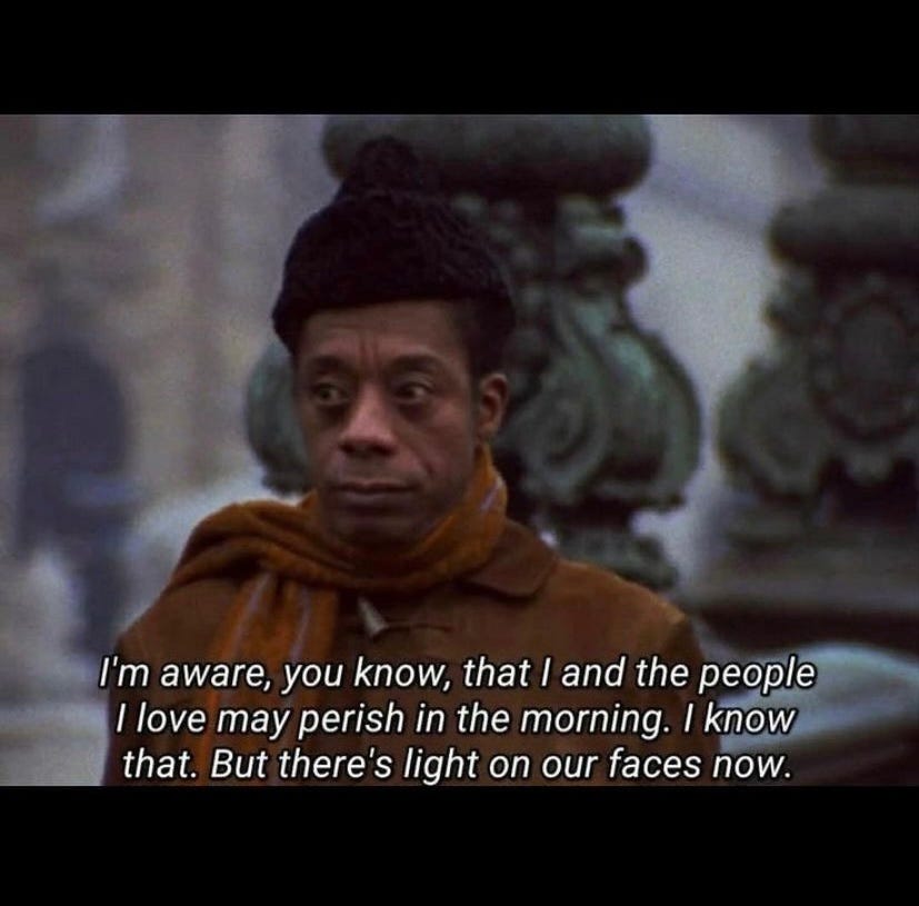 Color photo of James Baldwin wearing a black hat, brown jacket and scarf behind text added on top of the photo reading, “I’m aware, you know, that I and the people I love may perish in the morning. I know that. But there’s light on our faces now.” Color photo of James Baldwin wearing a black hat, brown jacket and scarf behind text added on top of the photo reading, “I’m aware, you know, that I and the people I love may perish in the morning. I know that. But there’s light on our faces now.”