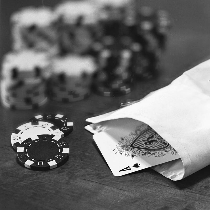 A black and white photo of poker chips and an Ace of Spades up the sleeve of a white shirt A black and white photo of poker chips and an Ace of Spades up the sleeve of a white shirt