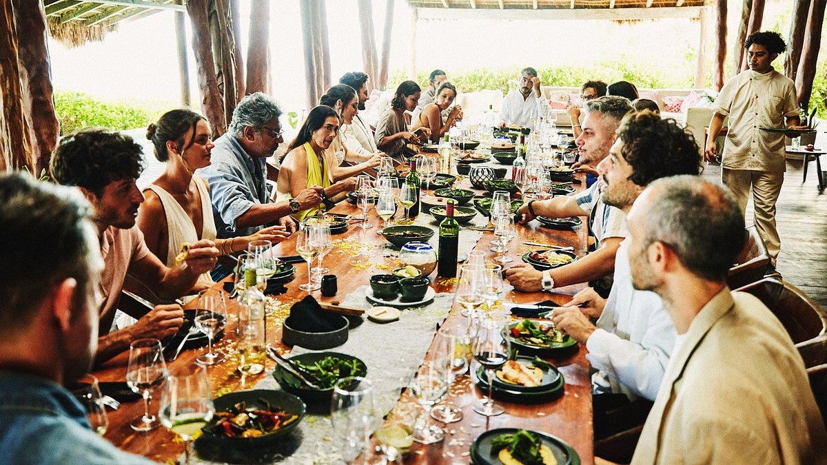 Friends and family dining at long table 