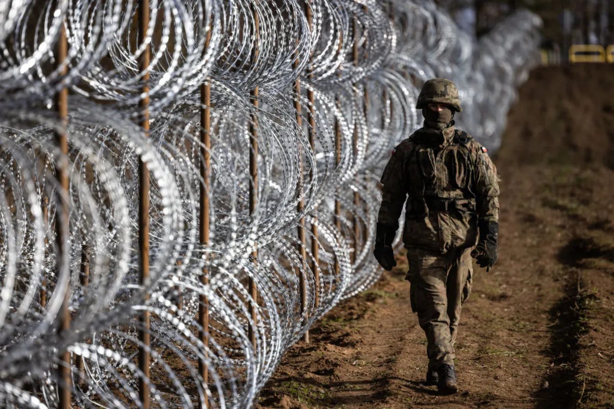 A Polish soldier walks near a fence on the Polish-Russian border in Kaliningrad Oblast region on November 3, 2022.
