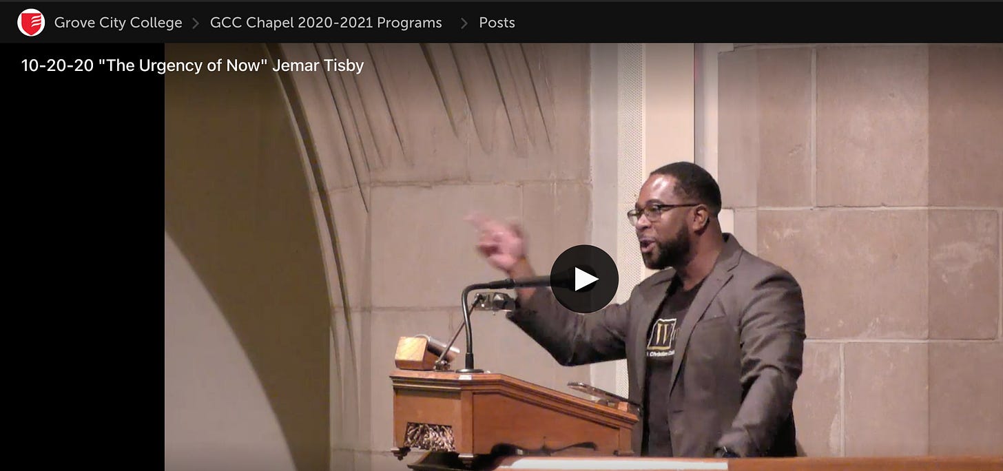 Jemar Tisby preaching at Grove City College, arm raised in the pulpit