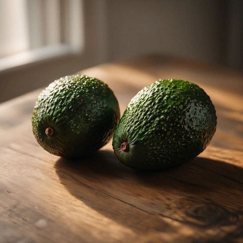 Two avocados sitting on a wooden table
Two avocados sitting on a wooden table