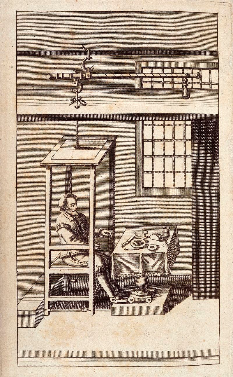 A man sitting in a chair-like contraption attached to a scale above for weighing him. A man sitting in a chair-like contraption attached to a scale above for weighing him.