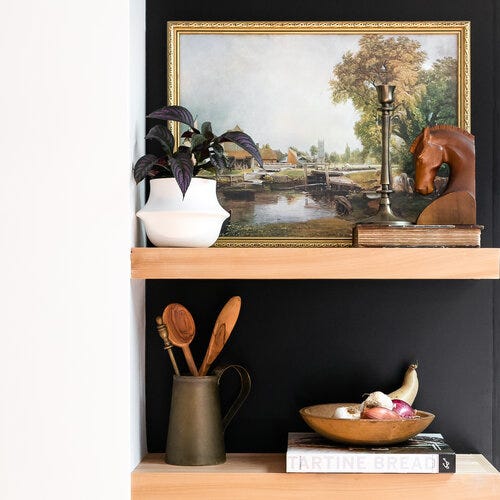 Floating shelf on a black wall.