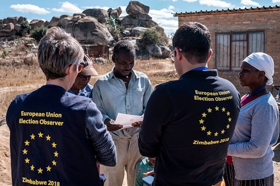 Two EU election observers speak to three villagers in Zimbabwe. Two EU election observers speak to three villagers in Zimbabwe.