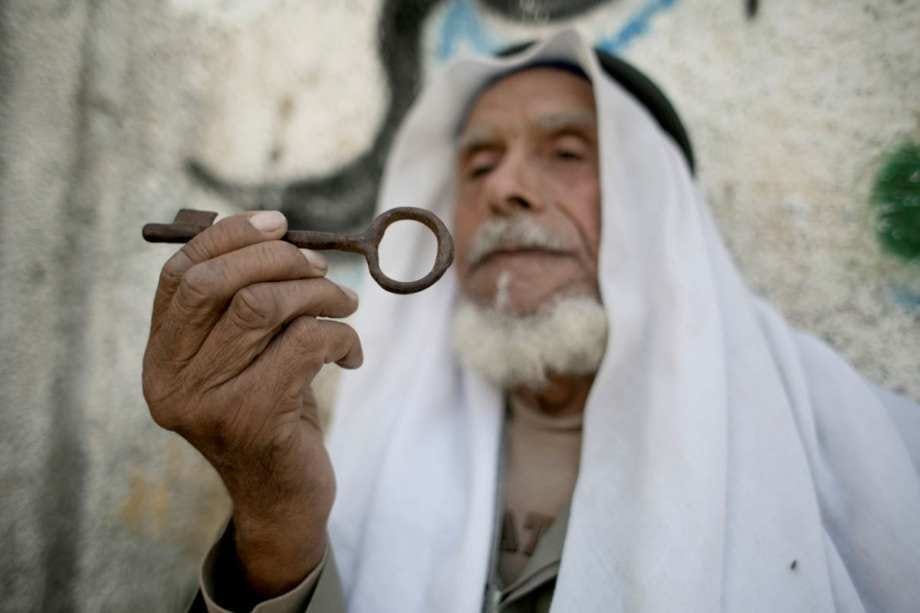 Palestinian refugee Ibrahim Abu Mustafa, 83, was forced out of his home in Beersheva during the Nakba. He carries the key to his former home as he sits outside his home in the Khan Yunis refugee camp in the southern Gaza Strip on 15 May 2016, on the 68th anniversary of the Nakba. [Said Khatib/AFP via Getty Images]