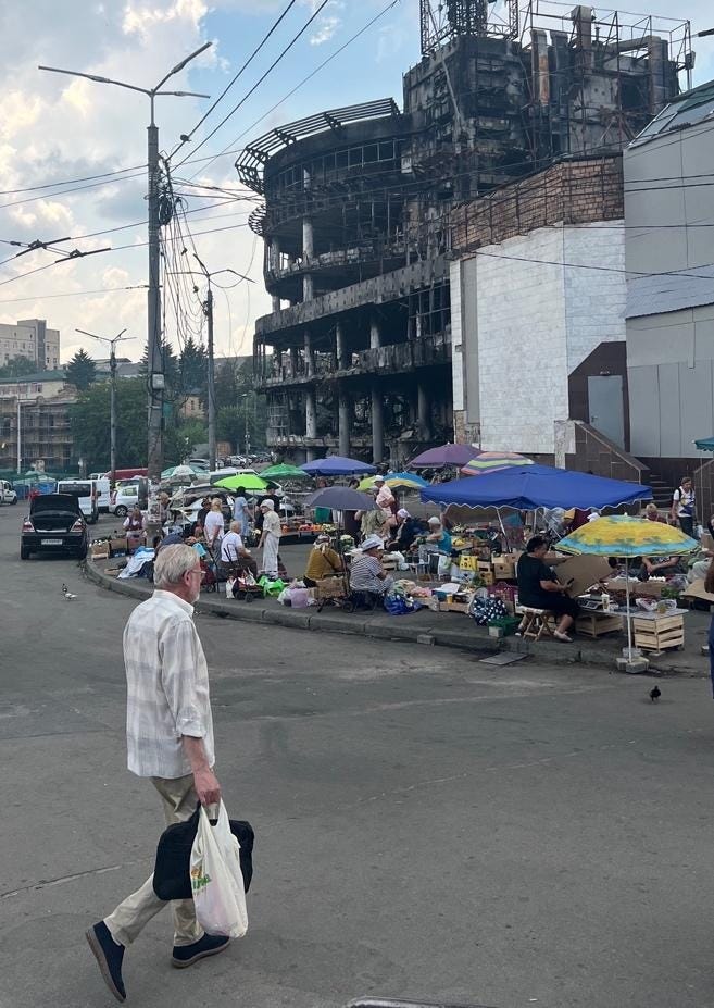 A person walking down a street with a group of people and a building

AI-generated content may be incorrect.