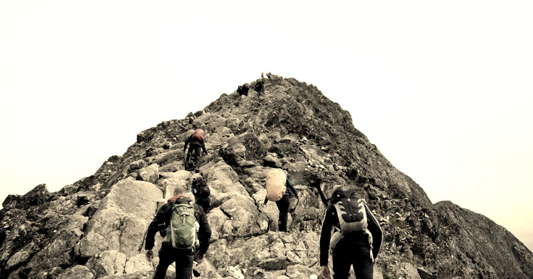 climbers hiking through mountain peak during daytime