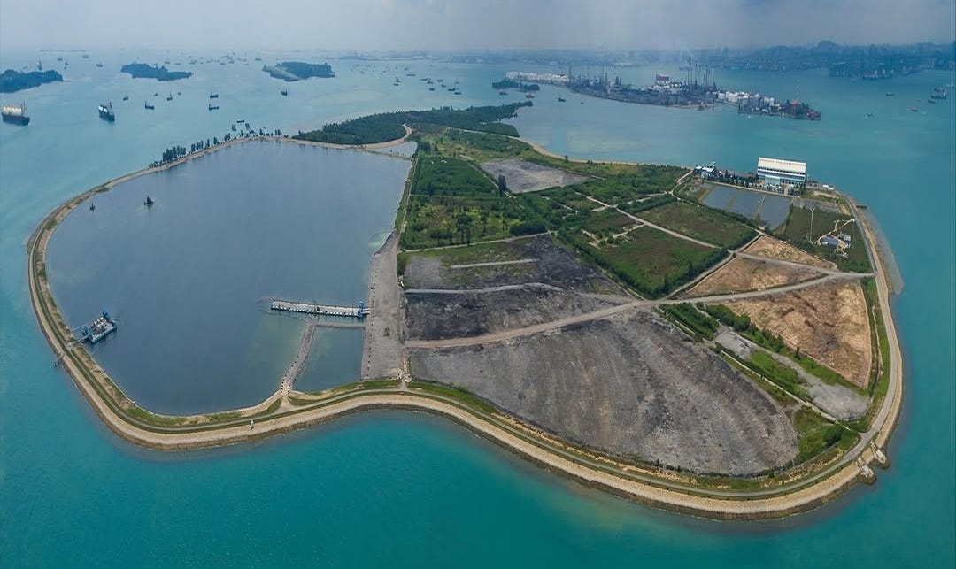 An island surrounded by blue sea, which is Semakau Island in Singapore, the world's largest offshore landfill