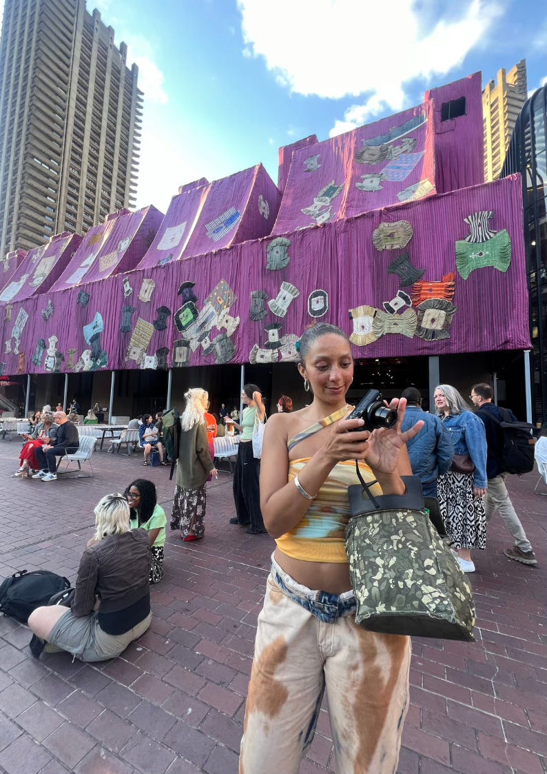 Nadia standing outside the Barbican Centre in London, a cultural hub known for its architecture and art exhibitions."