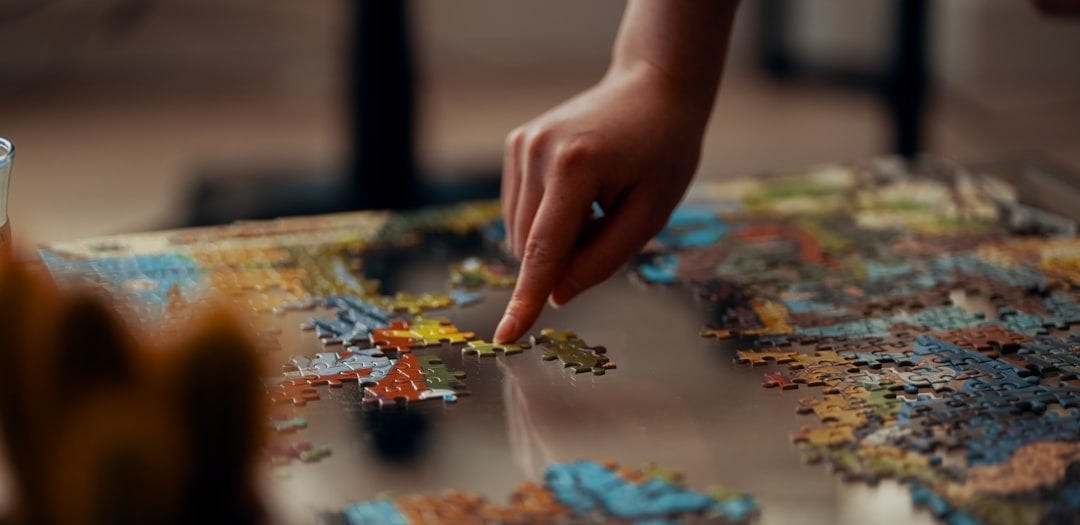 person holding jigsaw puzzle piece