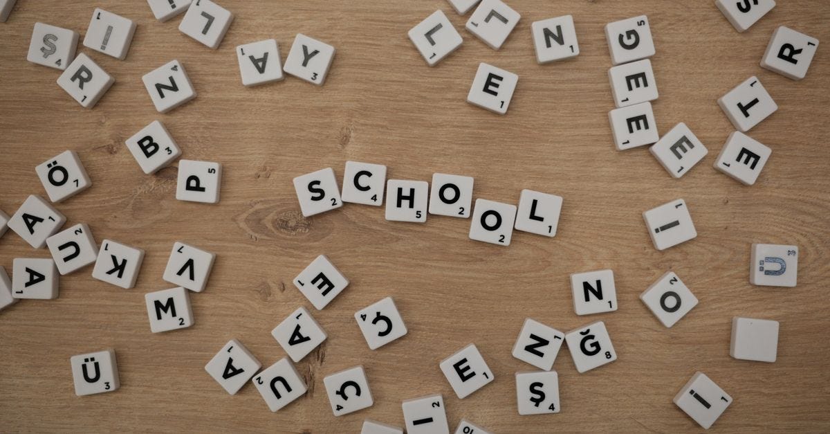 Photo: miniperde / Pexels Scattered Scrabble tiles on wood with 'School' spelled out, ideal for educational themes.