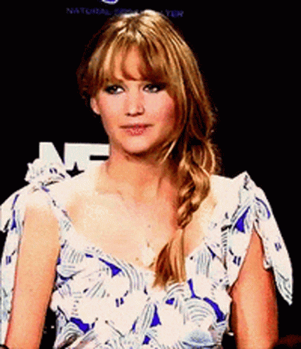 a woman wearing a blue and white floral dress stands in front of a sign that says natural beauty a woman wearing a blue and white floral dress stands in front of a sign that says natural beauty