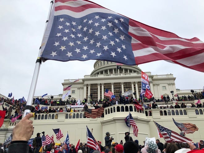 Rioters stand on the US Capitol building to protest the official election of President-elect Joe Biden on Jan. 6, 2021 on Washington DC. Rioters stand on the US Capitol building to protest the official election of President-elect Joe Biden on Jan. 6, 2021 on Washington DC.
