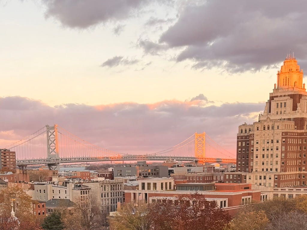An autumn cityscape is in the foreground, with a bridge in the background at golden hour An autumn cityscape is in the foreground, with a bridge in the background at golden hour