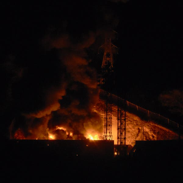 Fire and smoke surges behind a structure at the Fuerte Tiuna military complex.