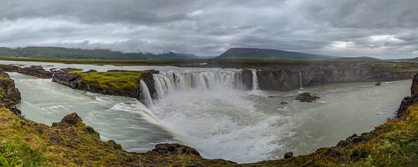A panorama shot of the falls showing two different levels under a grey sky. 