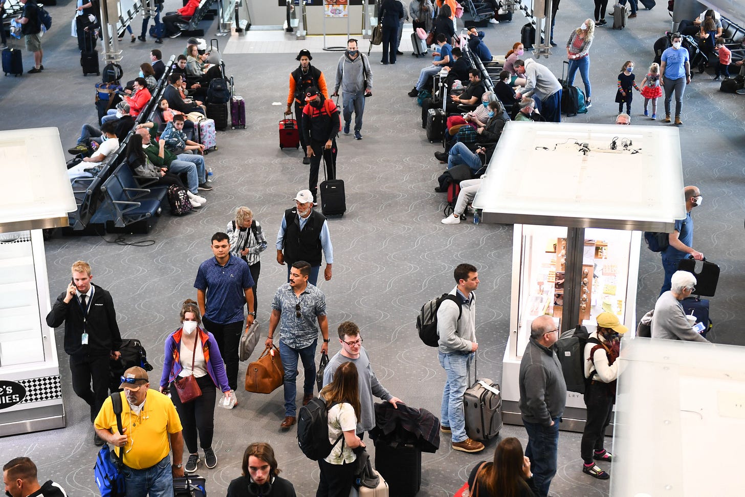 Airline passengers, some not wearing face masks following the end of Covid-19 public transportation rules, walk to flights at Denver International Airport on April 19, 2022. (Photo by Patrick T. Fallon/AFP via Getty Images) Airline passengers, some not wearing face masks following the end of Covid-19 public transportation rules, walk to flights at Denver International Airport on April 19, 2022. (Photo by Patrick T. Fallon/AFP via Getty Images)