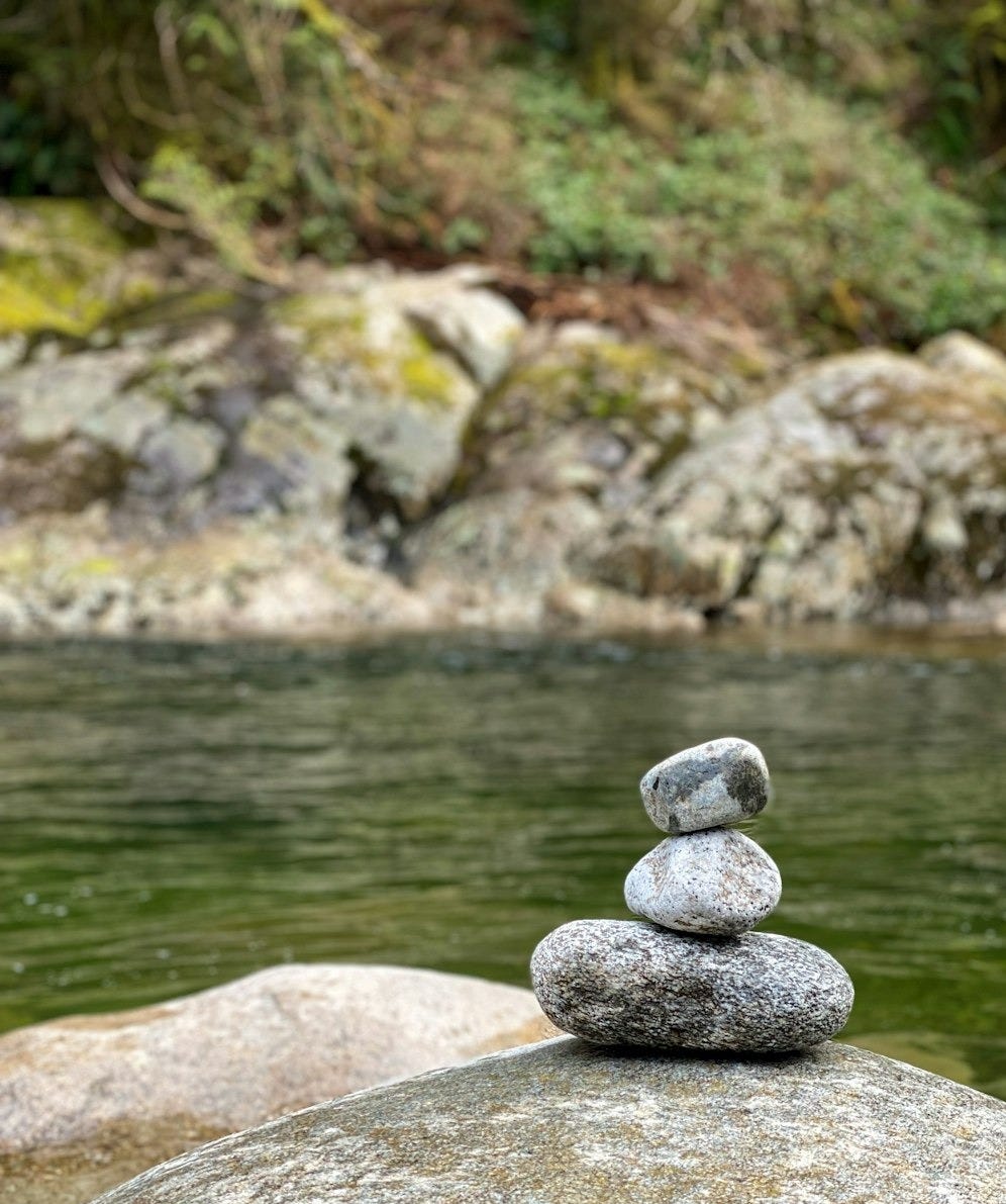 a pile of rocks sitting on top of a river