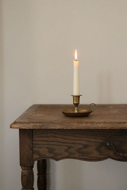 This may contain: a lit candle sitting on top of a wooden table