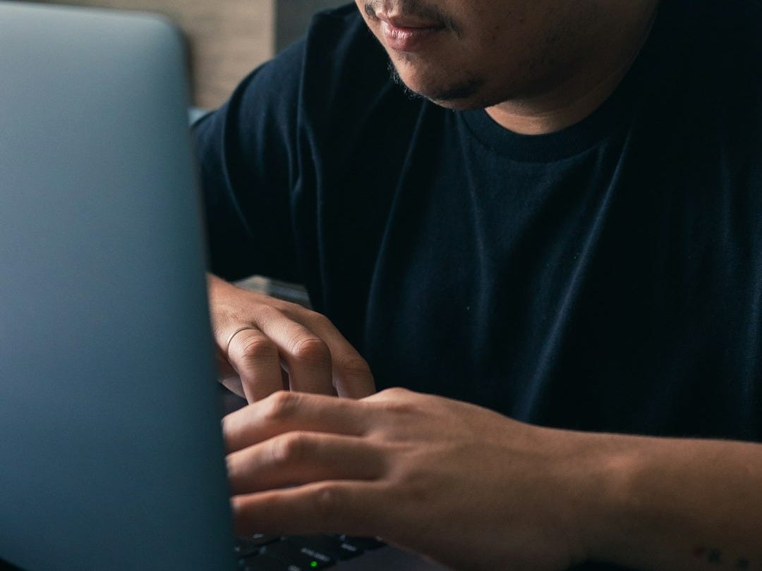 a man sitting in front of a laptop computer