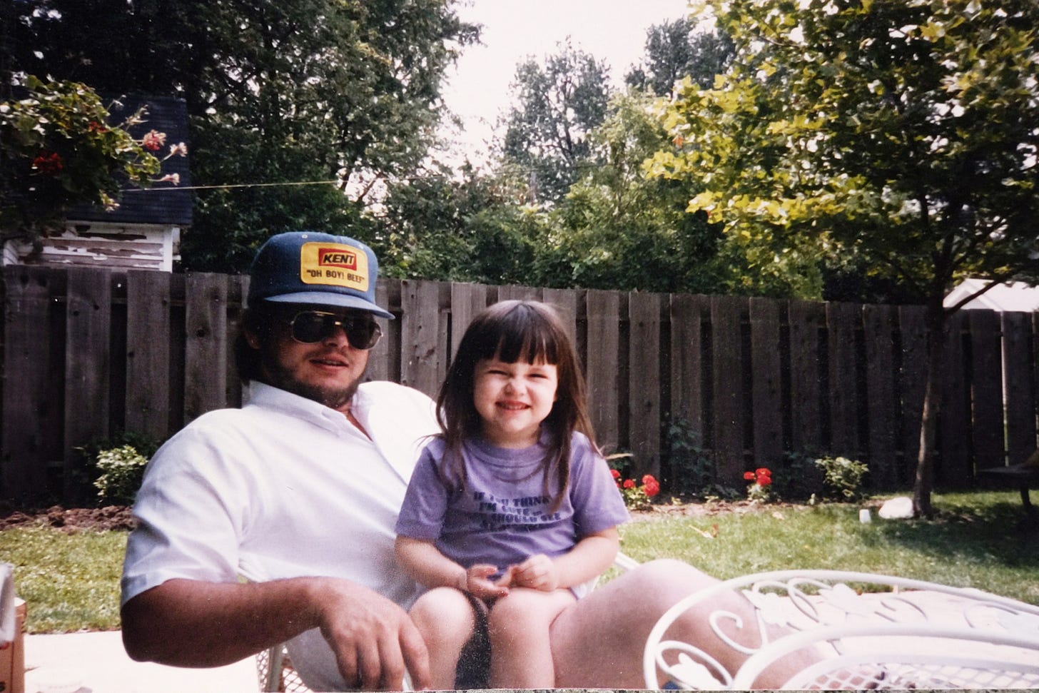 a four-year-old girl sits on her dad's lap