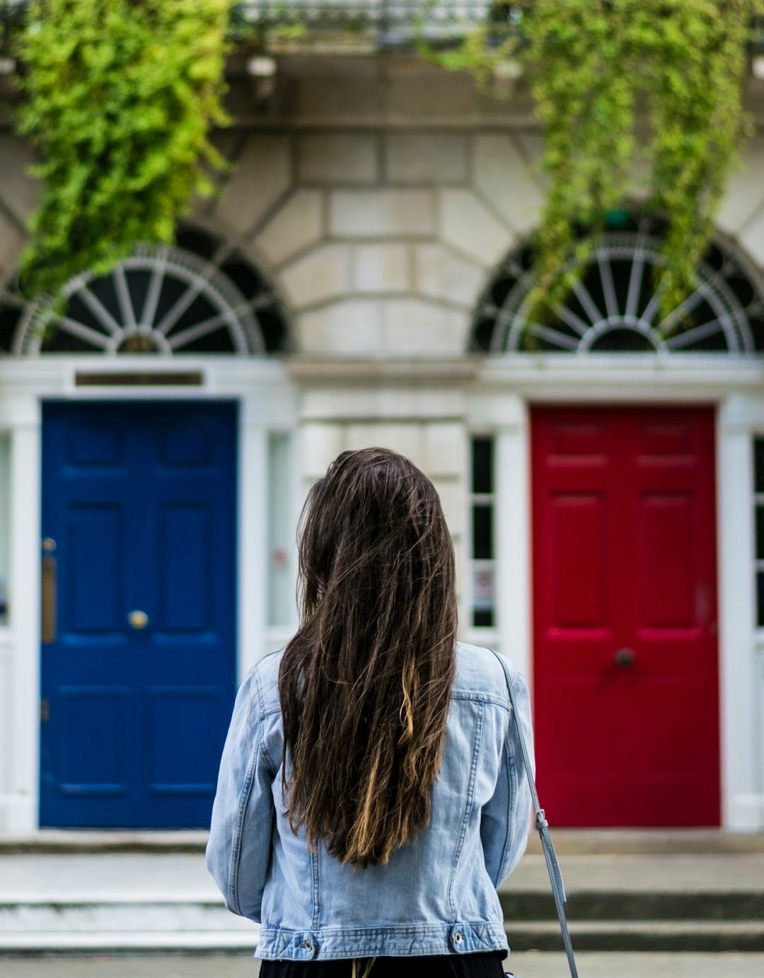 woman with jacket on front of concrete building