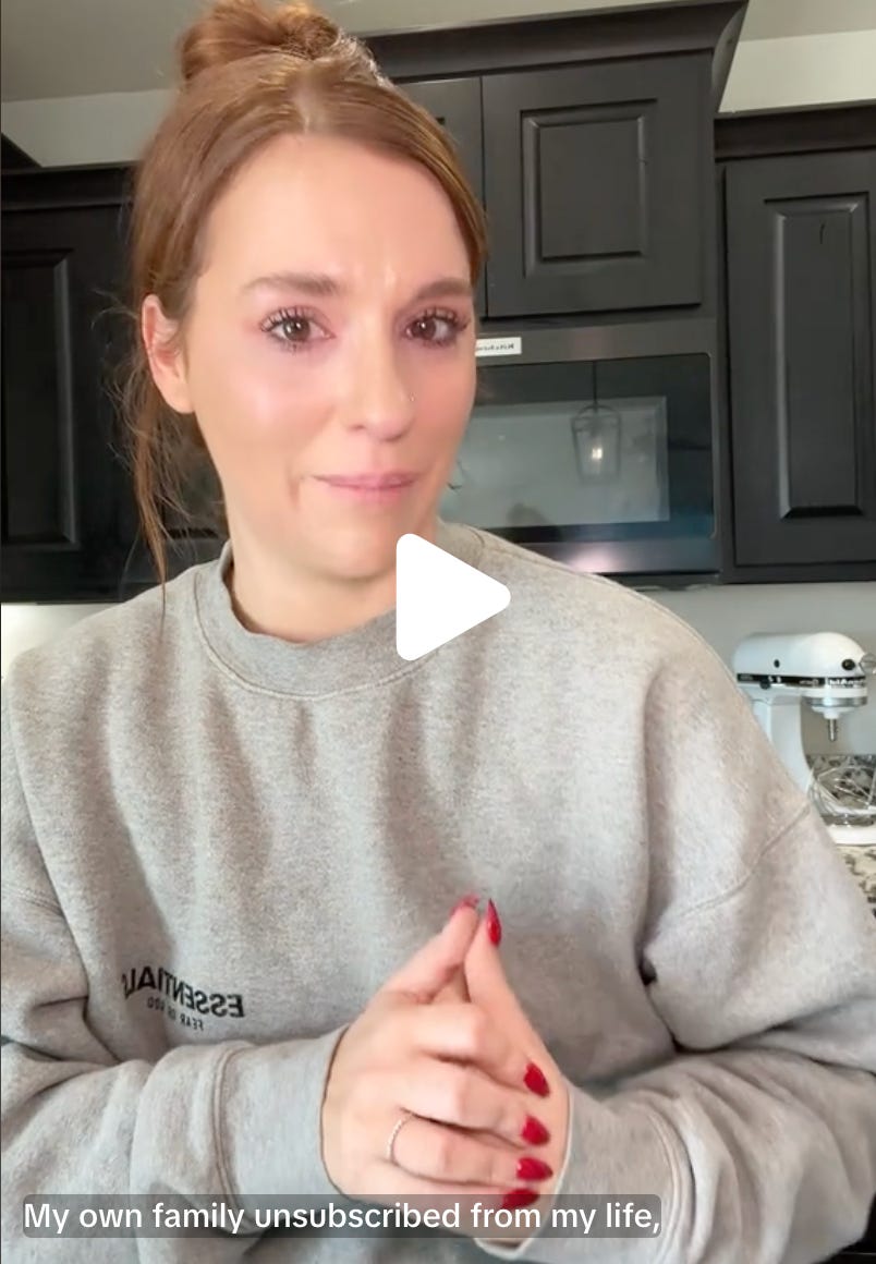 young white woman with brown hair pulled back, in kitchen, hands folded, trying not to cry, text says "My own family unsubscribed from my life"