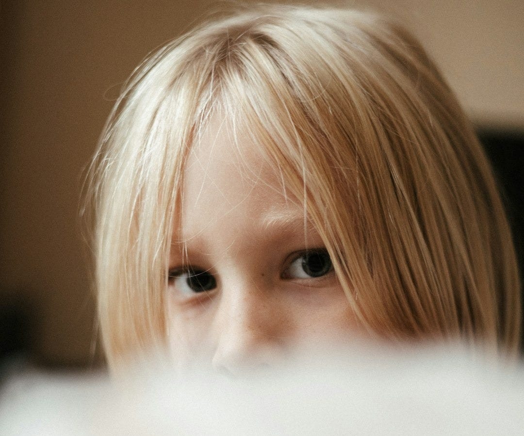 a close up of a child with blonde hair