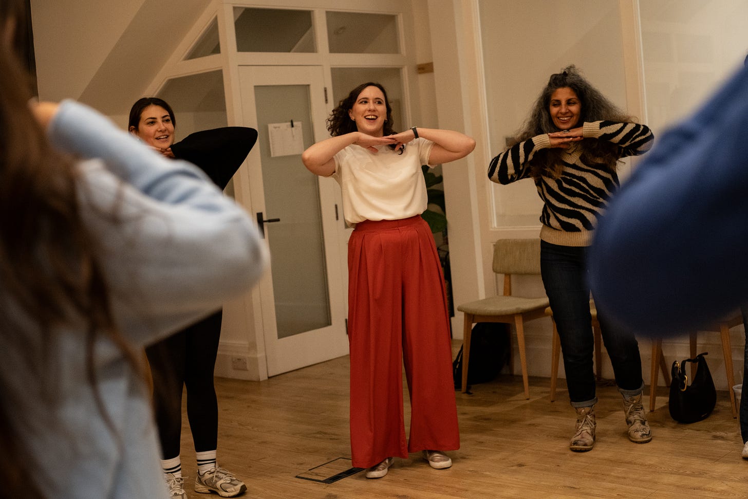 Charlie and other women standing, smiling and posing as part of a game Charlie and other women standing, smiling and posing as part of a game