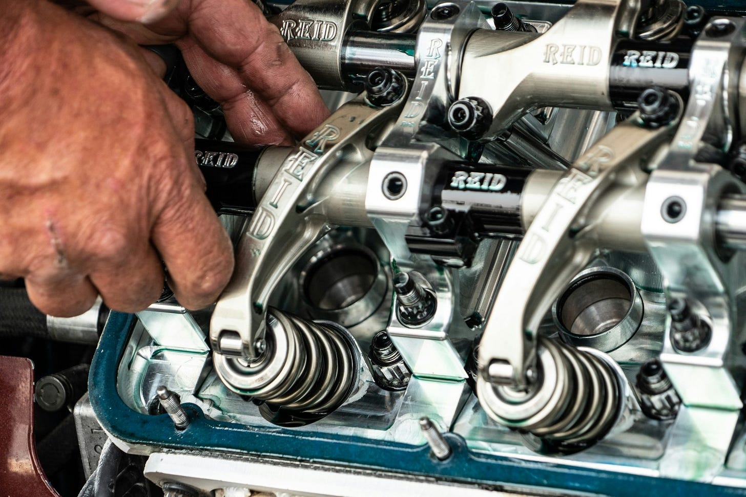 Hands fixing a car engine
