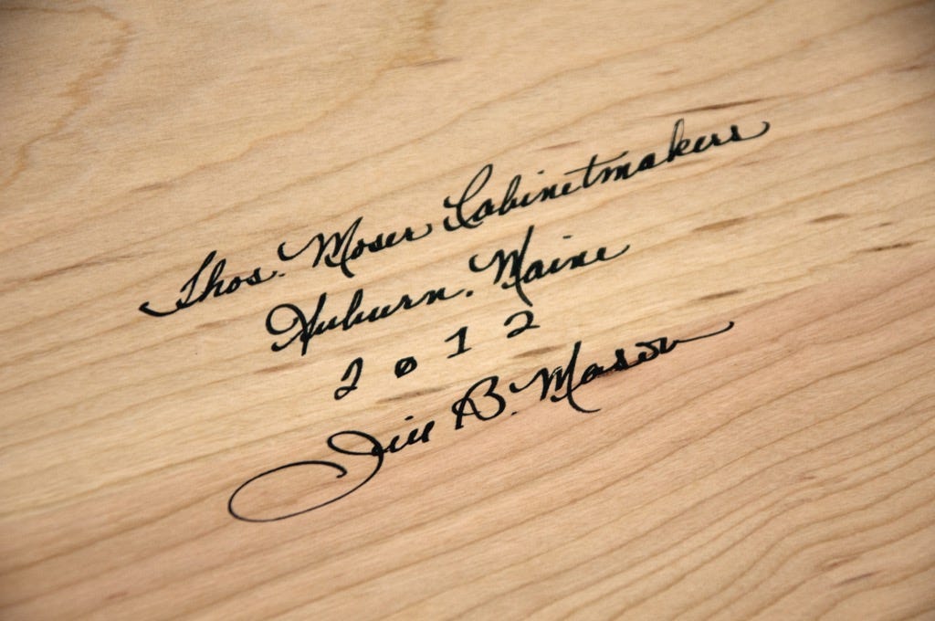 Cabinetmaker Jill B. Mason signs her work.