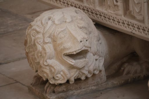 Sculpted lion with human-appearing teeth, looking like it's laughing
