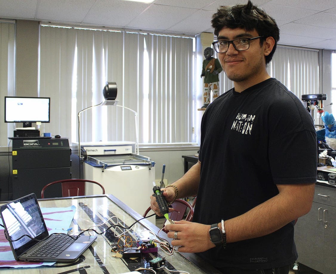 A person standing in front of a computer

Description automatically generated