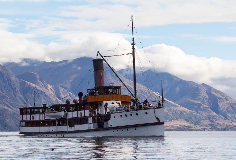 Uploaded imageThe TSS Earnslaw steamship on Lake Wakatipu, with mountains rising behind under scattered cloud.